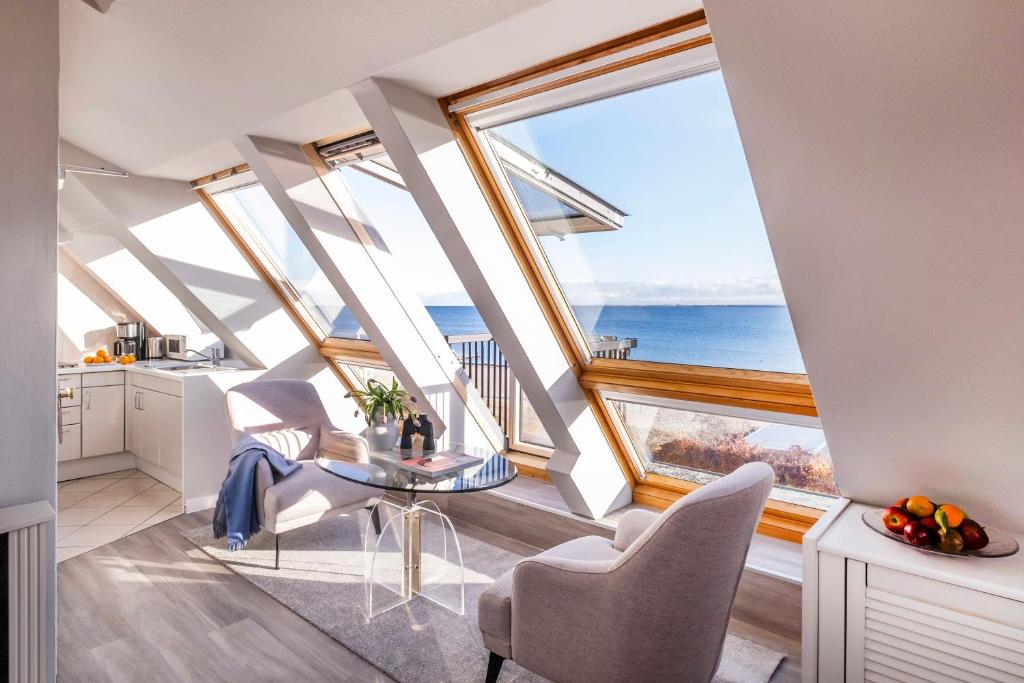 シュトランデにあるBüngers Apartment-Hotel, frisch renoviert mit Gartensaunaの大きな窓、テーブルと椅子付きのキッチンが備わります。