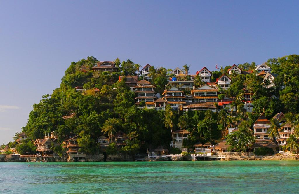 una isla con casas en una colina en el agua en Tropicana Ocean Villas, en Boracay
