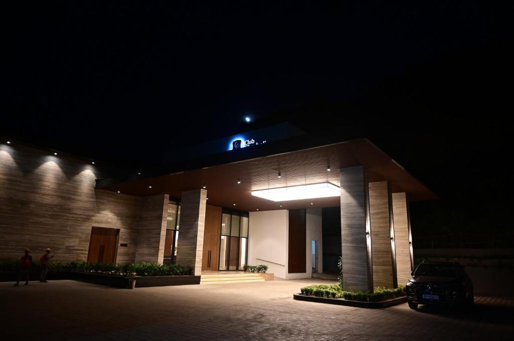 a building with a blue sign on top at night at Club Charholi in Lohogaon