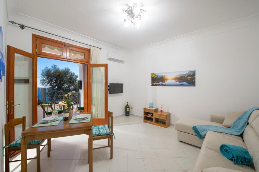 a living room with a table and a couch at Rosemary Holiday House in Conca dei Marini