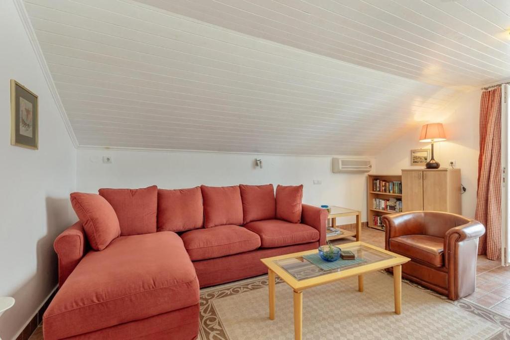 un salon avec un canapé rouge et une table dans l'établissement Detached Villa Njivice Sleeps6 Stunning Views Wifi, à Igalo