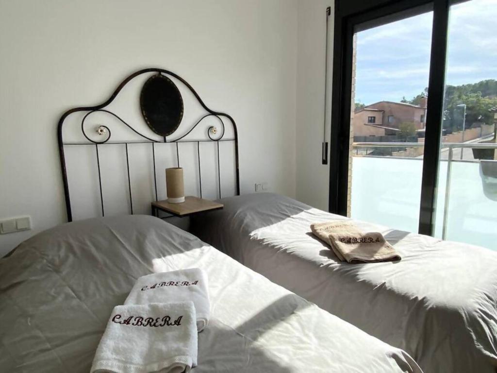 a bedroom with two beds with towels and a window at Escapada perfecta La Conca del Barberà in Santa Coloma de Queralt