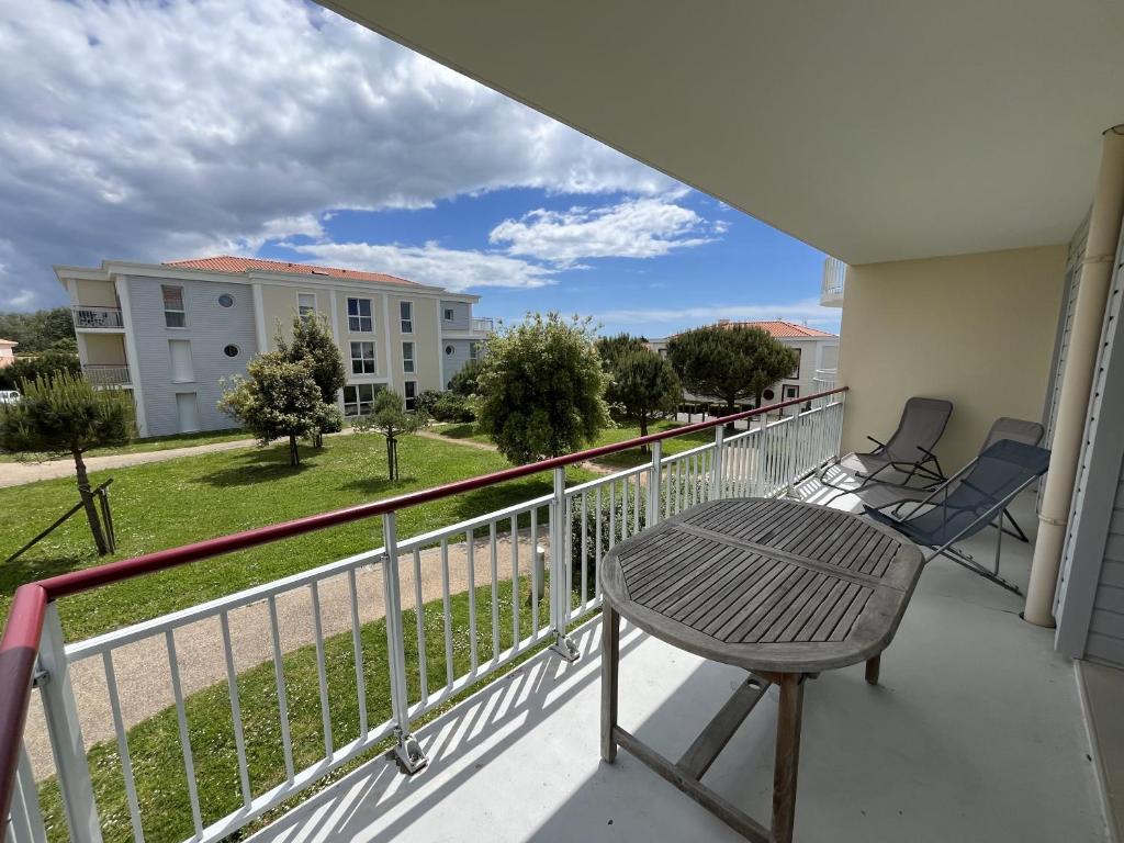 un balcon avec une table et des chaises sur un immeuble dans l'établissement Les Dunes, à Saint-Gilles-Croix-de-Vie