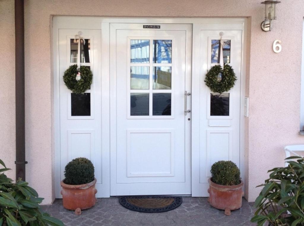 a white front door with wreaths on it at Gästezimmer Kippenhausen in Immenstaad am Bodensee