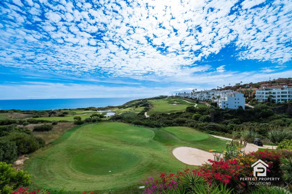 a view of a golf course with the ocean at Golfer's paradise - 2BR with garage and pool in San Roque
