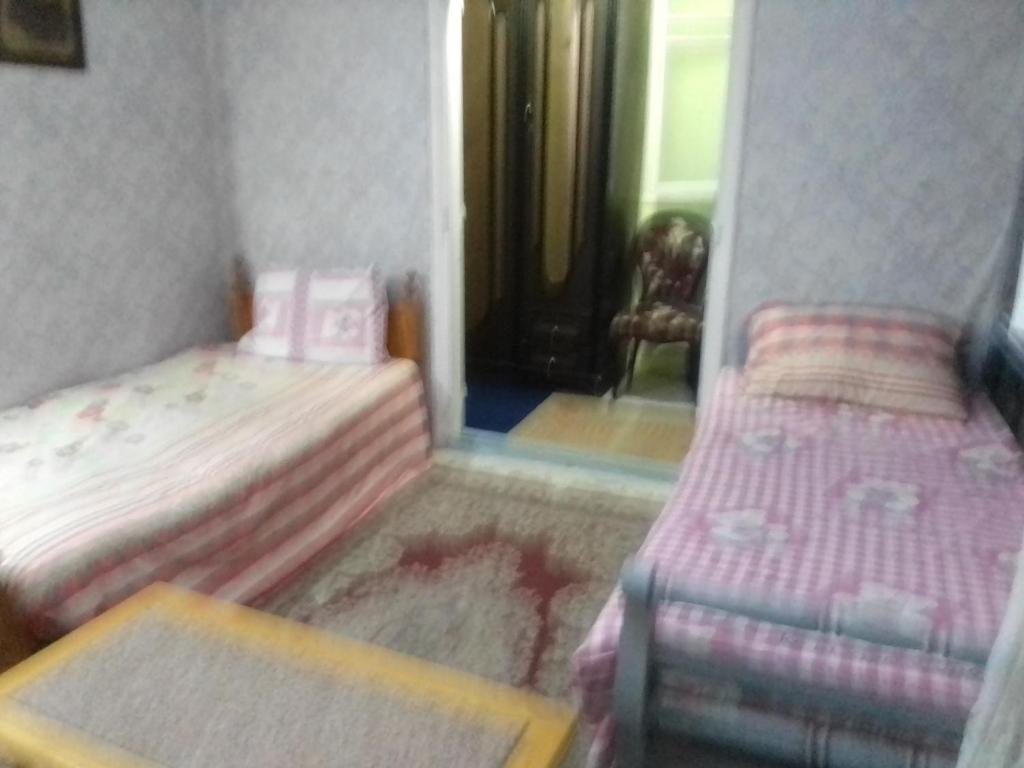 a small bedroom with two beds and a mirror at كمب شيزار ادفو 35 in Alexandria