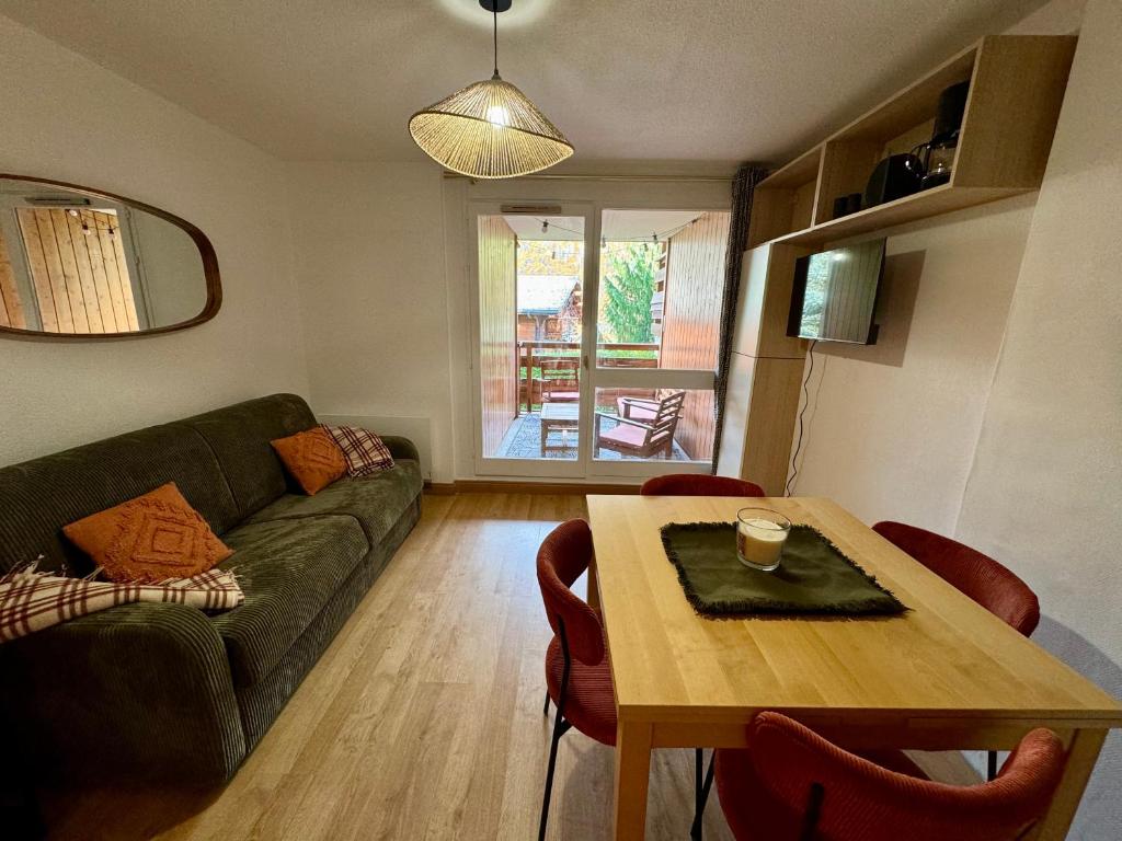 un salon avec un canapé vert et une table dans l'établissement Snow & Sun, Morzine, 4 personnes, à Morzine