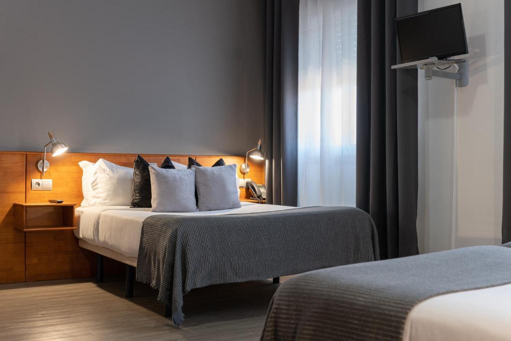 A bed or beds in a room at Hotel Carlos 96
