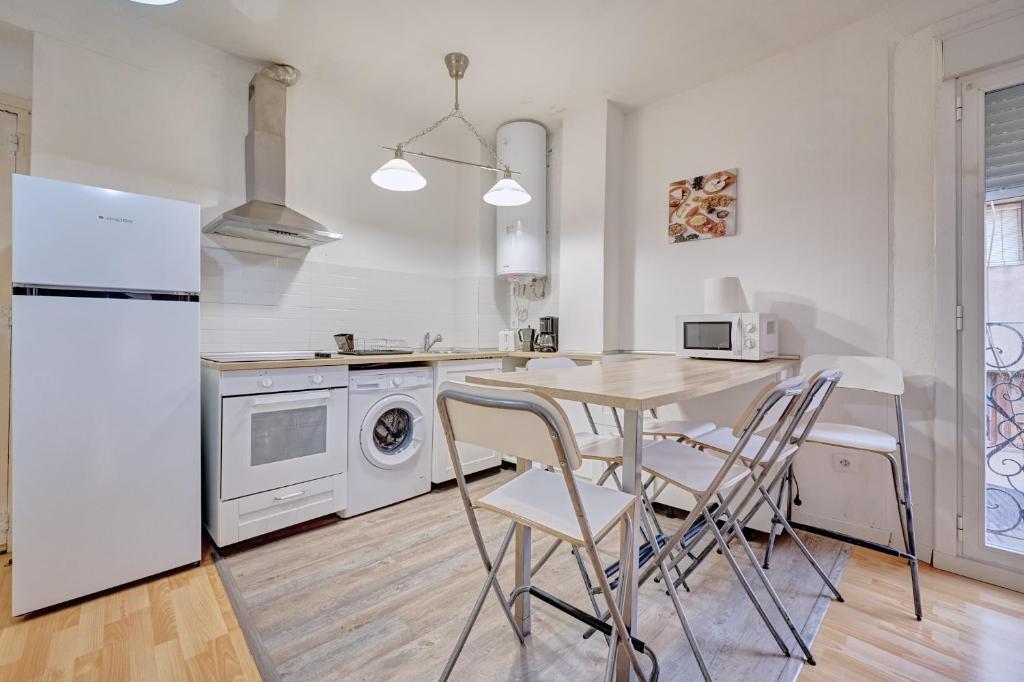 a kitchen with a table and chairs and a refrigerator at Santo Tomás D in Haro
