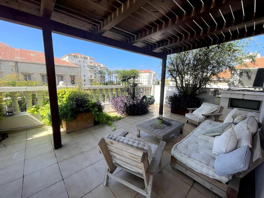 Jaffa Rooftop Studio with Sea Views في تل أبيب: فناء مع أريكة وكراسي على الفناء