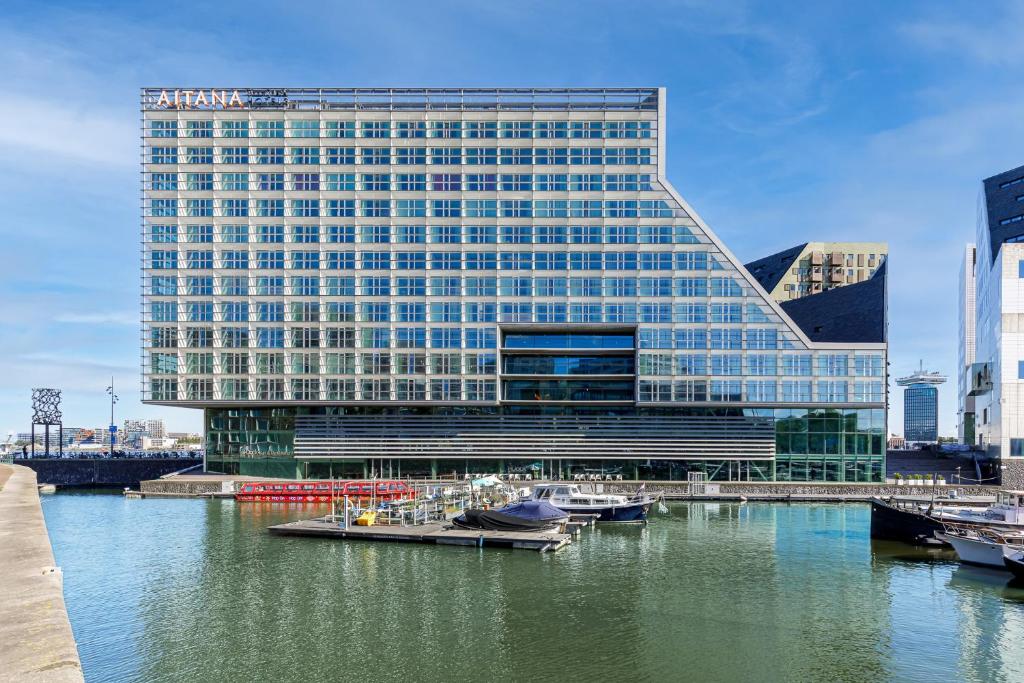 a building with boats in the water in front of it at Room Mate Aitana, Amsterdam in Amsterdam
