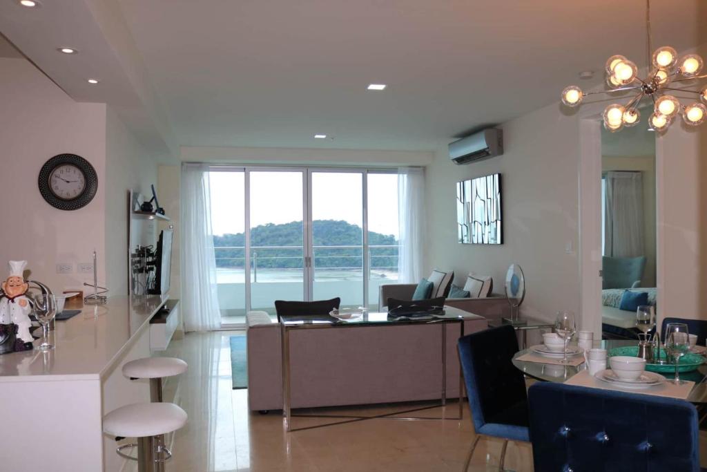 a kitchen and living room with a table and chairs at Spectacular Condo With Oceanview in Playa Bonita Village