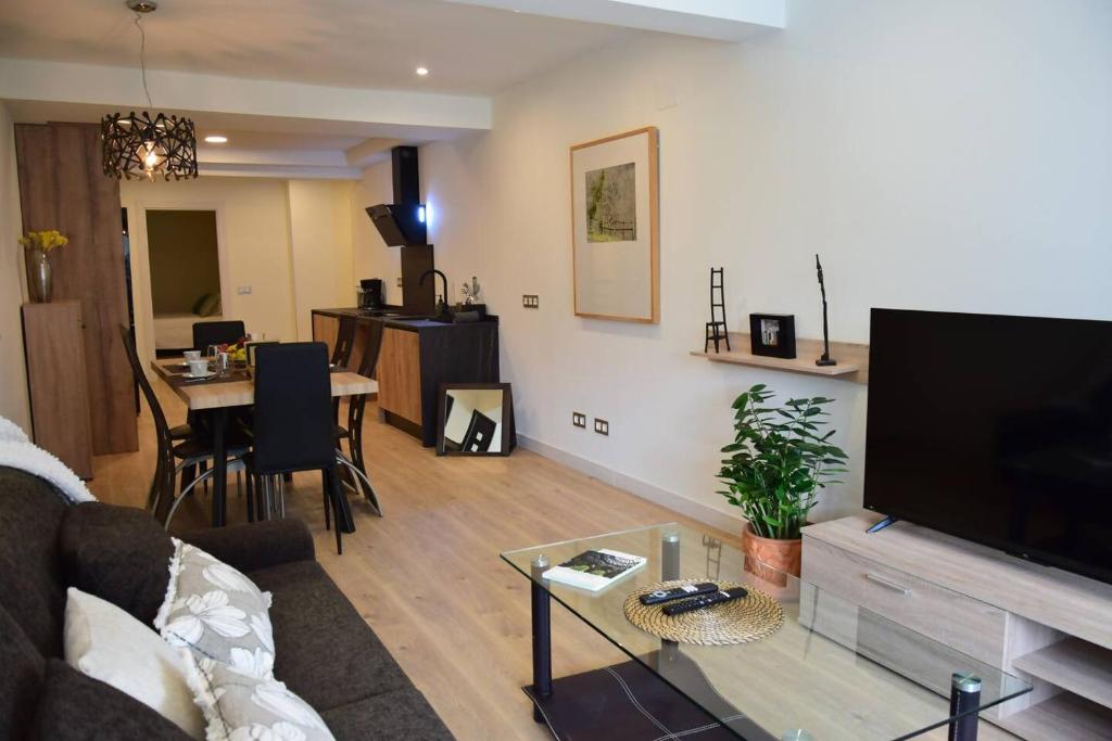 ein Wohnzimmer mit Sofa und Flachbildfernseher in der Unterkunft Espacioso apartamento a 9 min playa in Gijón