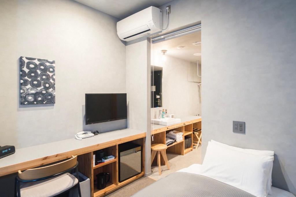 盛岡市にあるホテルマザリウムのベッド1台、テレビ、デスクが備わる客室です。