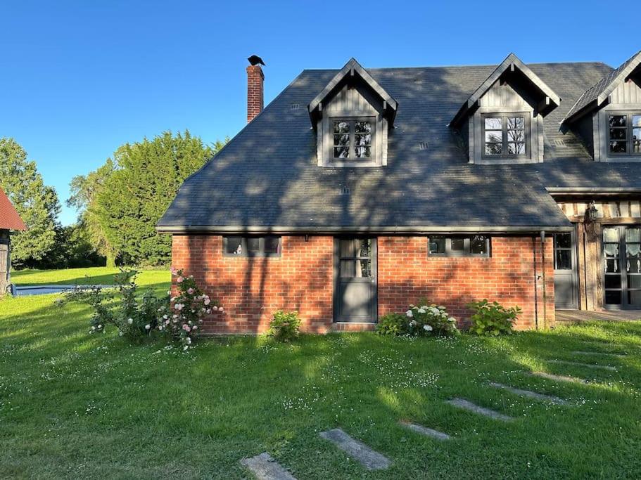 a brick house with two windows on a green lawn at Sublime propriété Normande véritable havre de paix in Danestal
