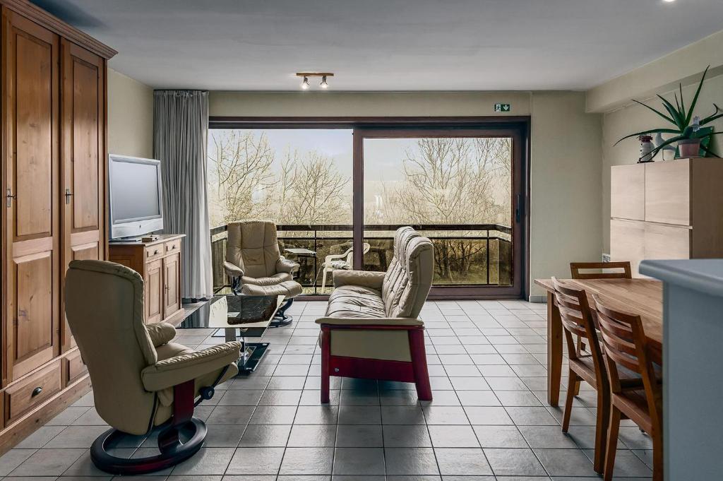 a living room with chairs and a large window at Mathieu 1 - A2 G in Oostduinkerke
