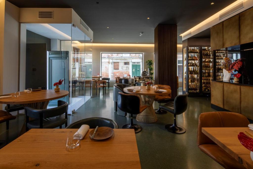 a restaurant with tables and chairs and a bar at Ca' Bonfadini Historic Experience in Venice
