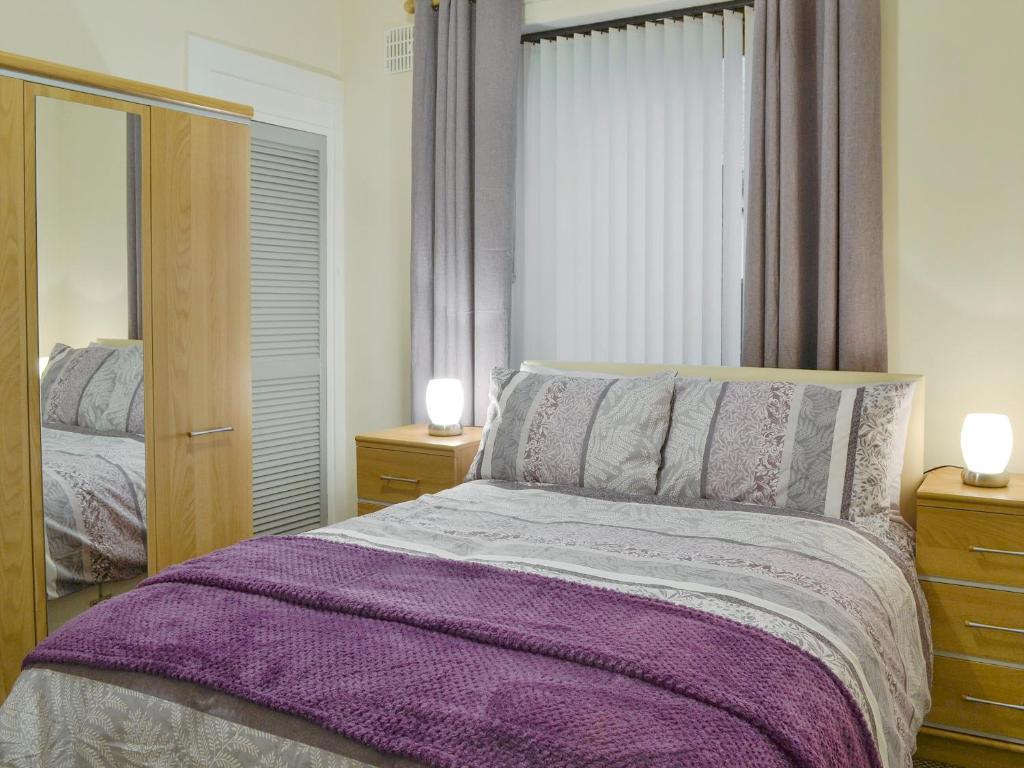 a bedroom with a bed with a purple blanket at Bankfield - Uk5660 in Aberdeen