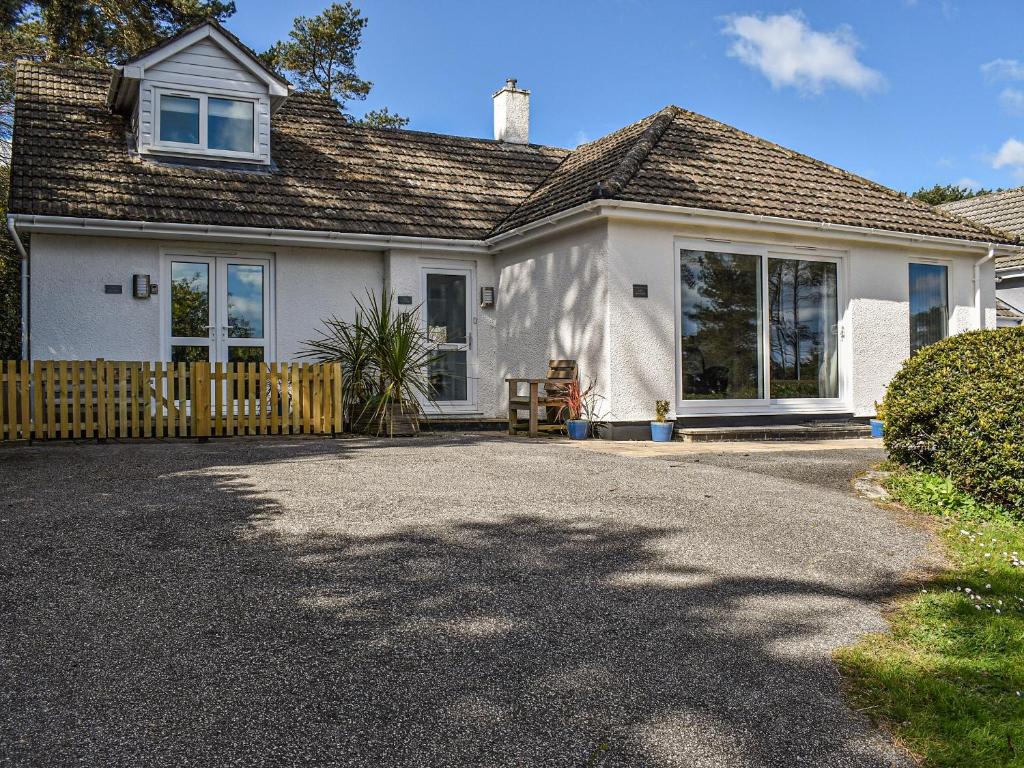 ein weißes Haus mit einem Zaun und einer Einfahrt in der Unterkunft Bunker - Uk11039 in Carlyon Bay