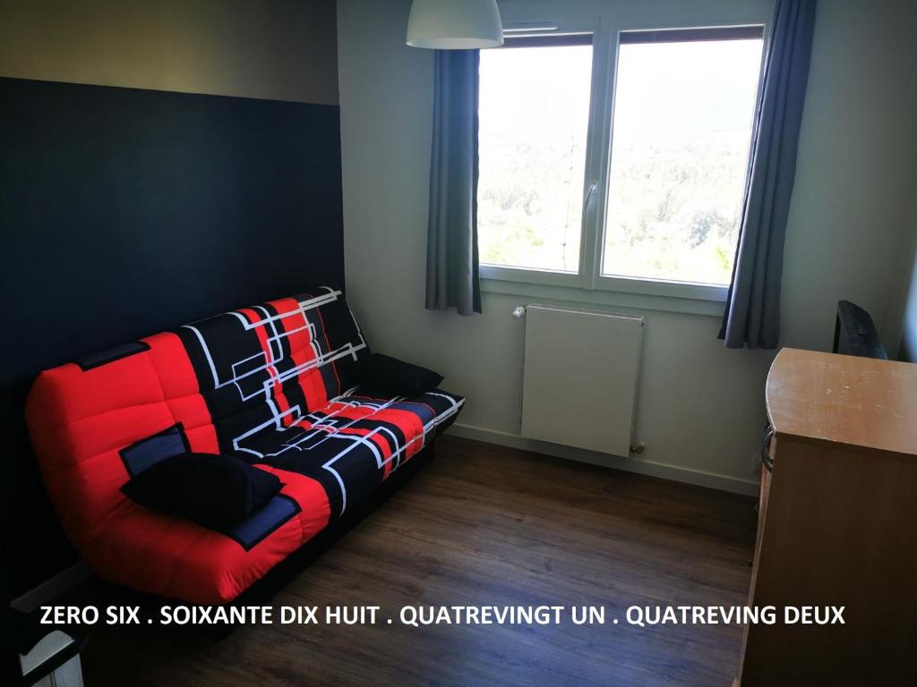 een bank in een kamer met een raam bij Olympiades in Annecy