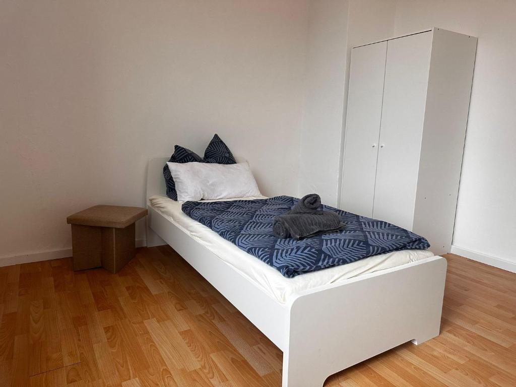Cette petite chambre comprend un lit blanc avec des draps bleus. dans l'établissement Ferienwohnung im Herzen von Betzdorf, à Betzdorf