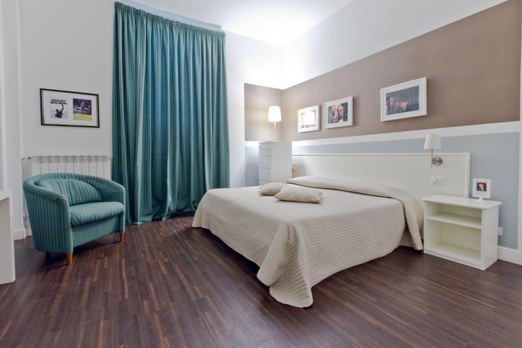 sypialnia z łóżkiem i zielonym krzesłem w obiekcie Cinema House w Rzymie