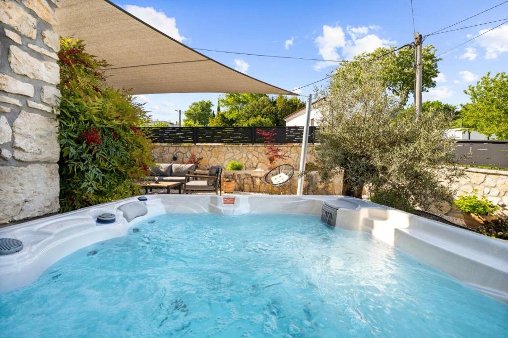 a hot tub in a backyard with an umbrella at House Bruna in Kršan