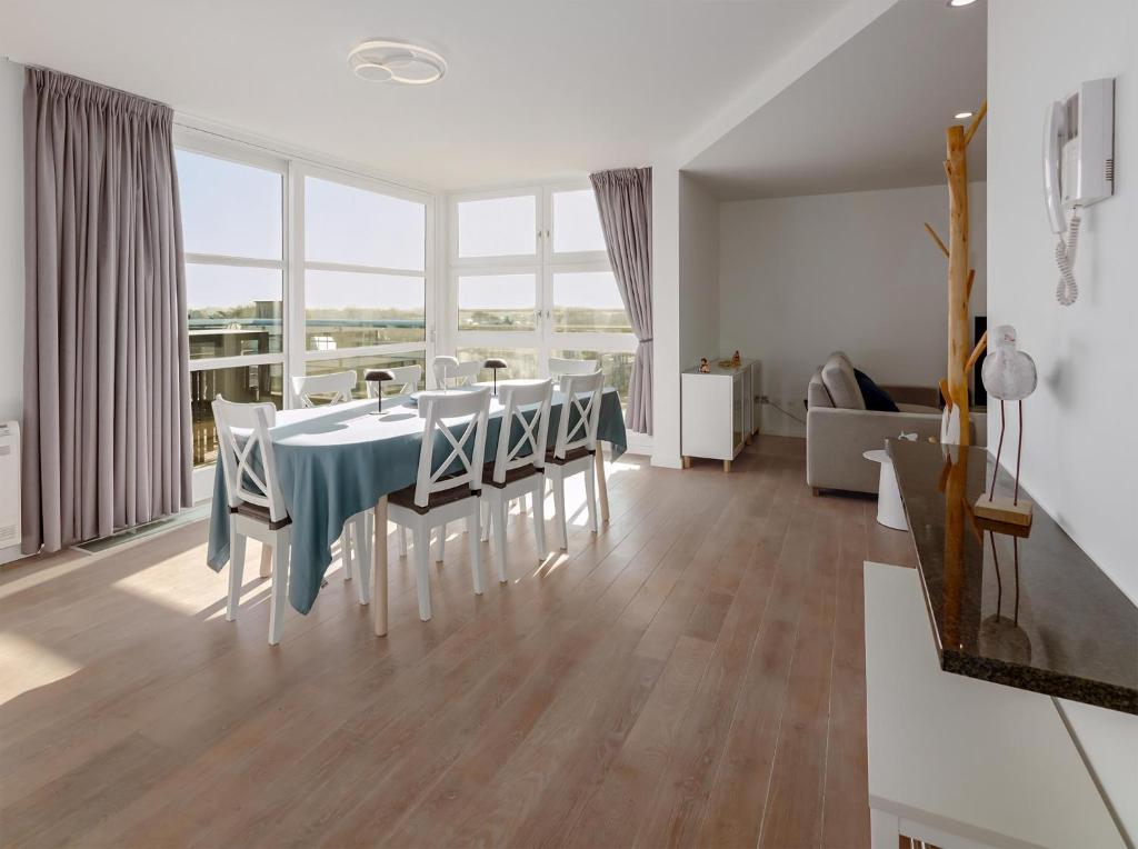 Una cocina y un comedor con mesa y sillas. en Nausicaa 0501 G, en Oostduinkerke