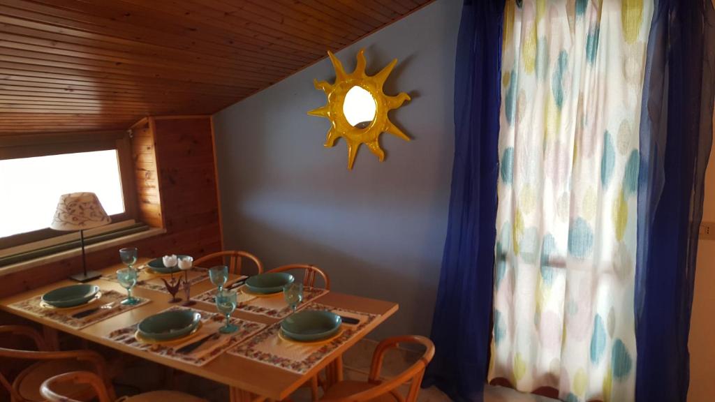 a dining room with a table and a clock on the wall at Casa Diana in Giardini Naxos