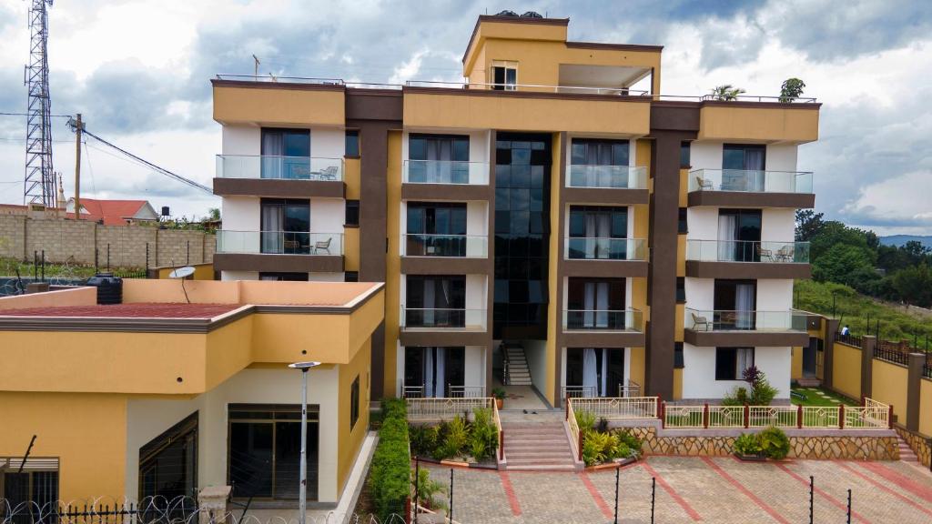 a yellow apartment building with a balcony at Masese Heights in Jinja