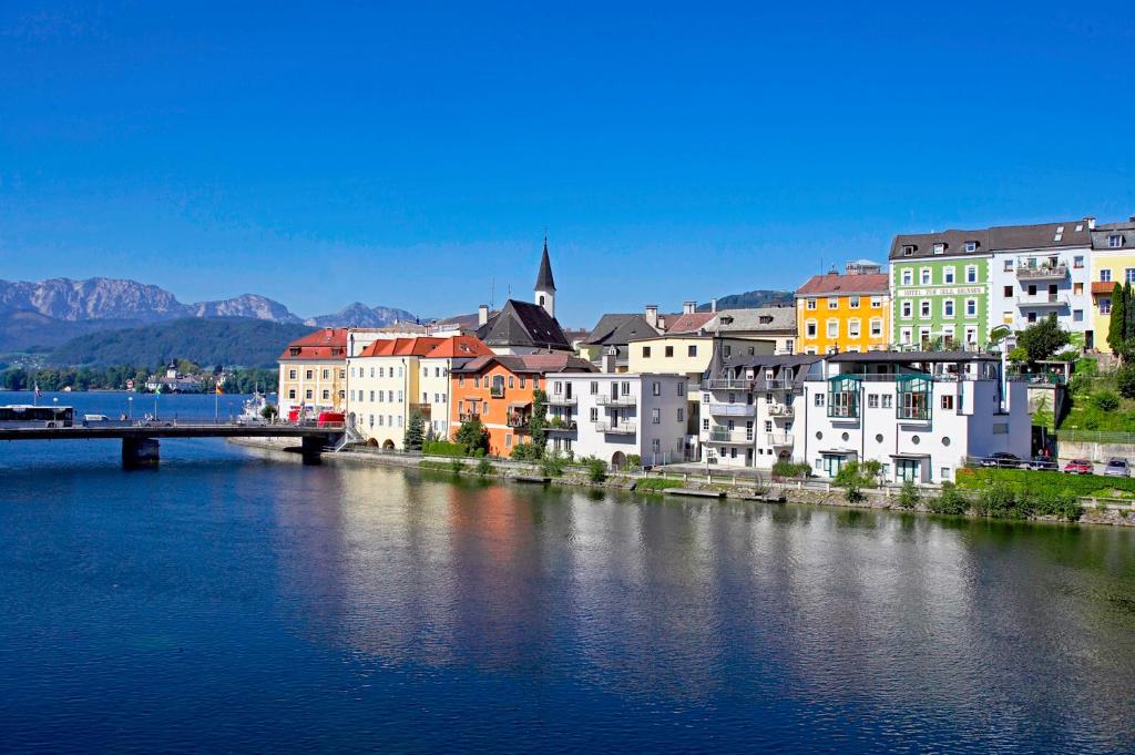 Eine Stadt mit einer Brücke über einen Wasserkörper in der Unterkunft Keramikhotel Goldener Brunnen in Gmunden