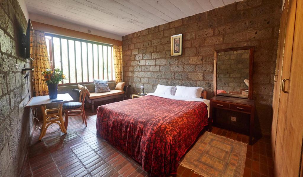 a hotel room with a bed and a mirror at Villa Rock Stop Falls Gigiri in Nairobi