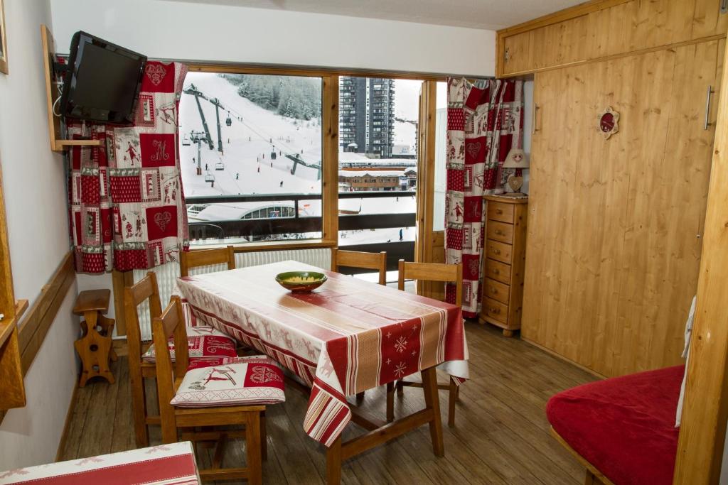 une pièce avec une table, des chaises et une fenêtre dans l'établissement Les MENUIRES la Croisette Appt 6 pers Coeur de station, aux Menuires