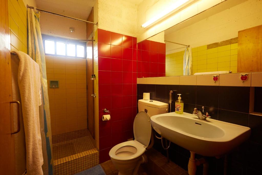 a bathroom with a toilet and a sink and a mirror at Villa Rock Stop Falls Gigiri in Nairobi