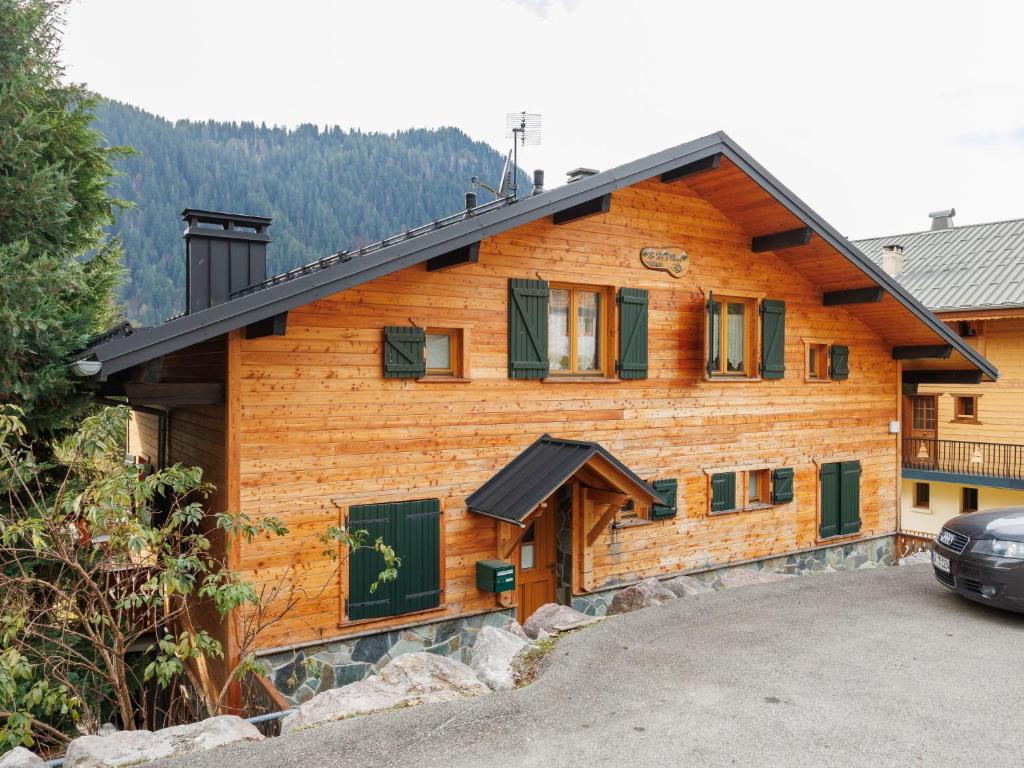 une maison en bois avec une voiture garée devant elle dans l'établissement Apartment Fer à Cheval-1 by Interhome, à Châtel