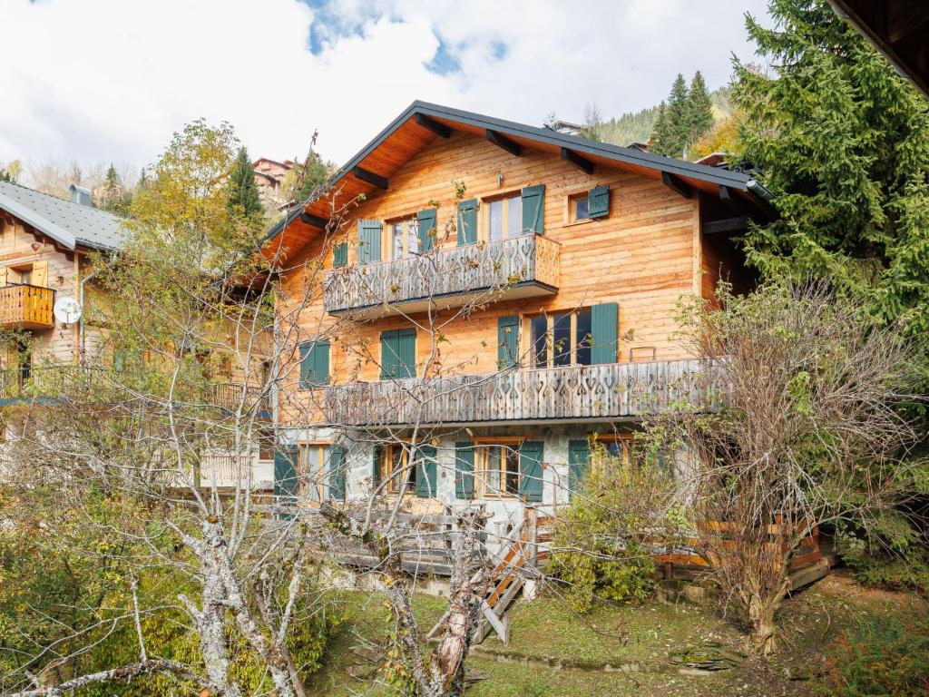 Cette maison en bois possède un balcon dans les bois. dans l'établissement Apartment Fer à Cheval-3 by Interhome, à Châtel