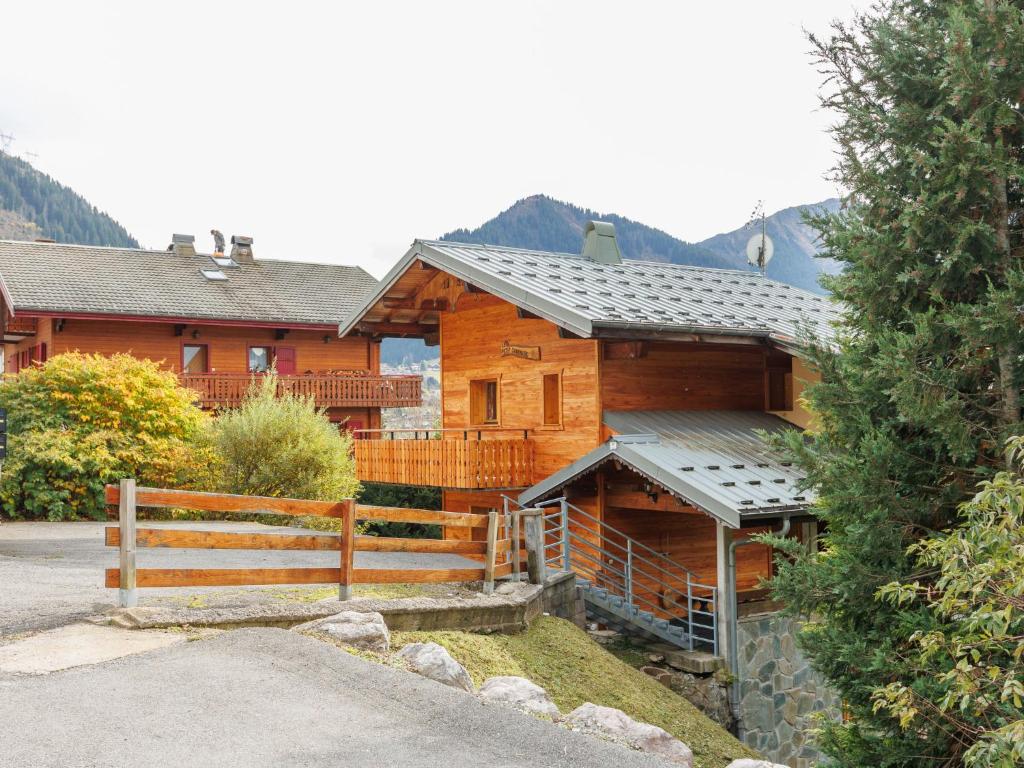 une maison en bois avec une clôture devant elle dans l'établissement Apartment Le Petit Savoyard-3 by Interhome, à Châtel
