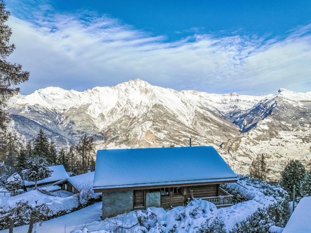 a house in the snow with mountains in the background at Chalet La Bergerie by Interhome in Nendaz