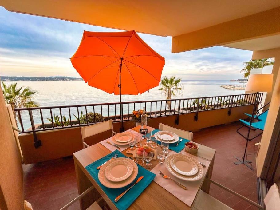 - une table à manger avec un parasol et une vue sur l'océan dans l'établissement T3 Bandol vue mer - Les pieds dans l'eau, à Bandol