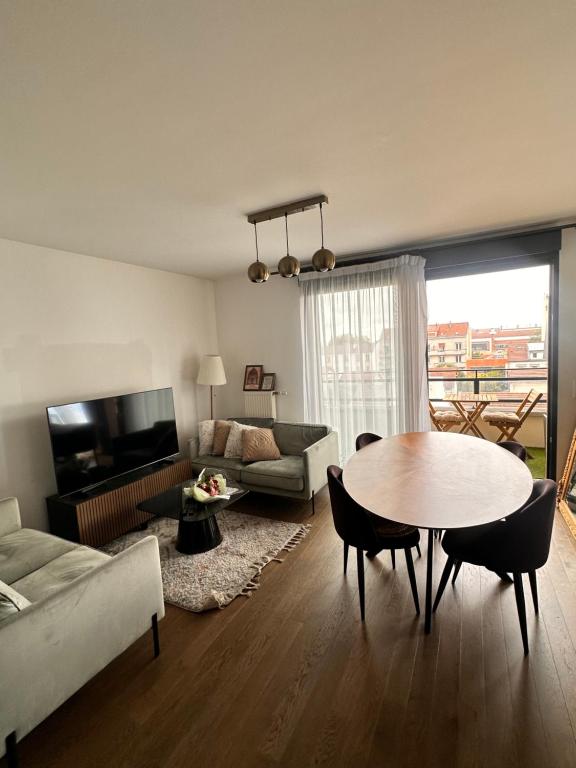 un salon avec une table et un canapé dans l'établissement Le Central, à Colombes