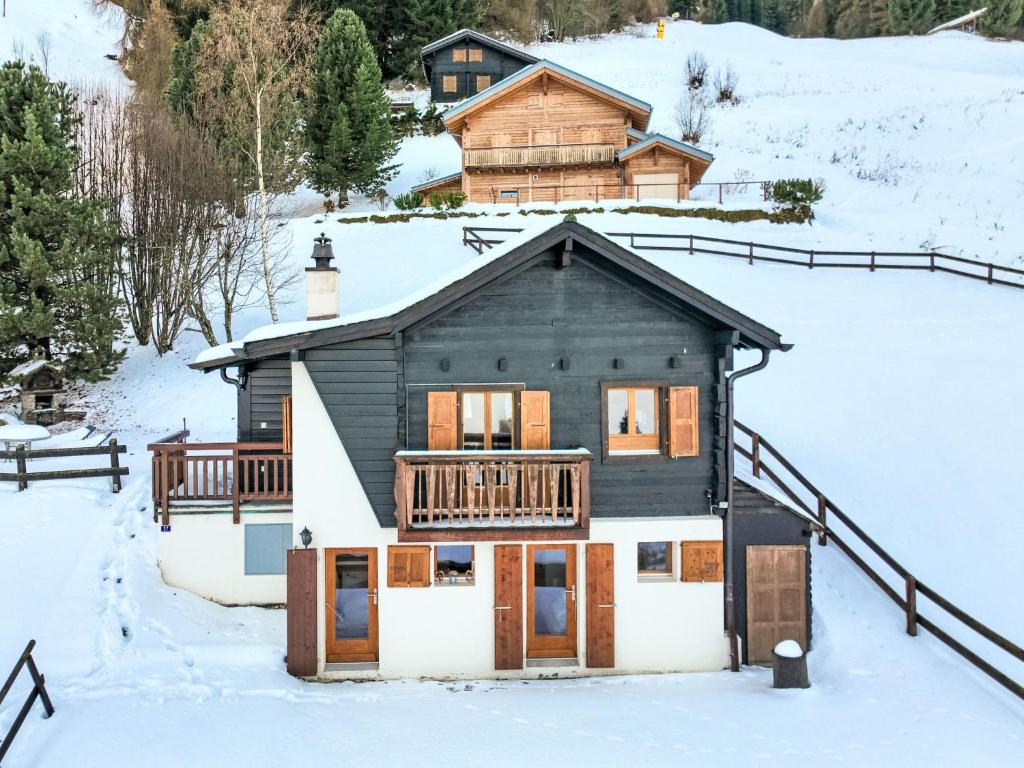 a house with a deck in the snow at Chalet Le Ruisseau by Interhome in Nendaz