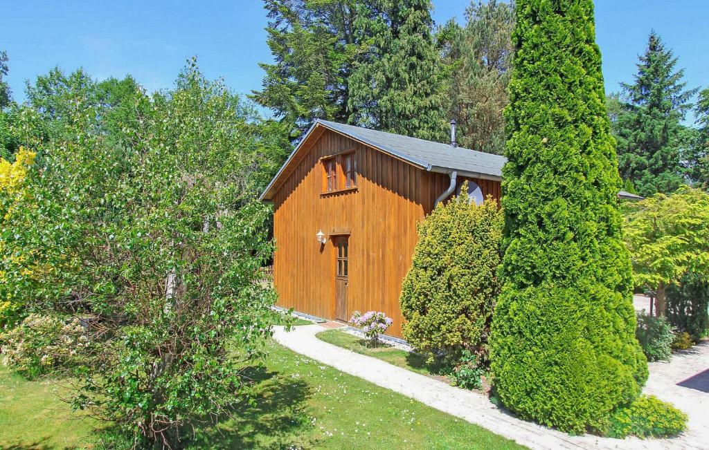 a small wooden building in a yard with trees at Ferienwohnung Bodstedt in Bodstedt