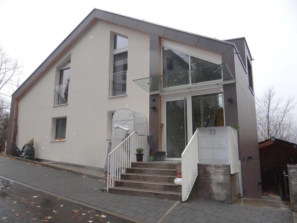 une maison blanche avec un escalier en face de celle-ci dans l'établissement Apartment Studentenweg 33 by Interhome, à Engelberg