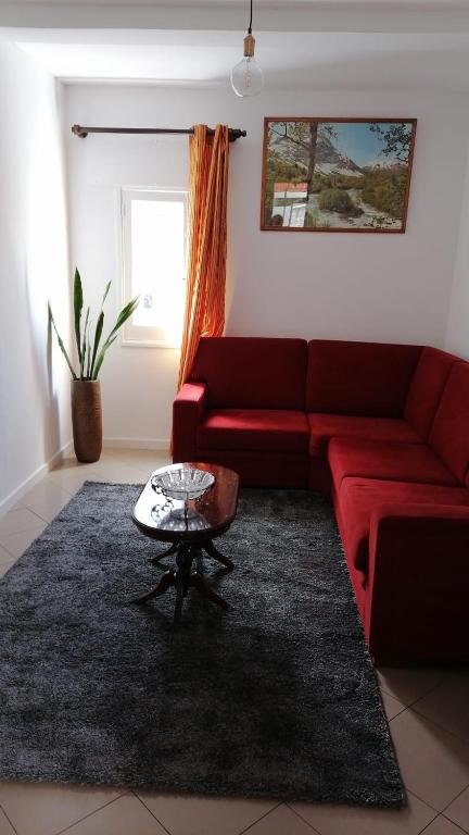 a living room with a red couch and a table at Madeira property in Câmara de Lobos