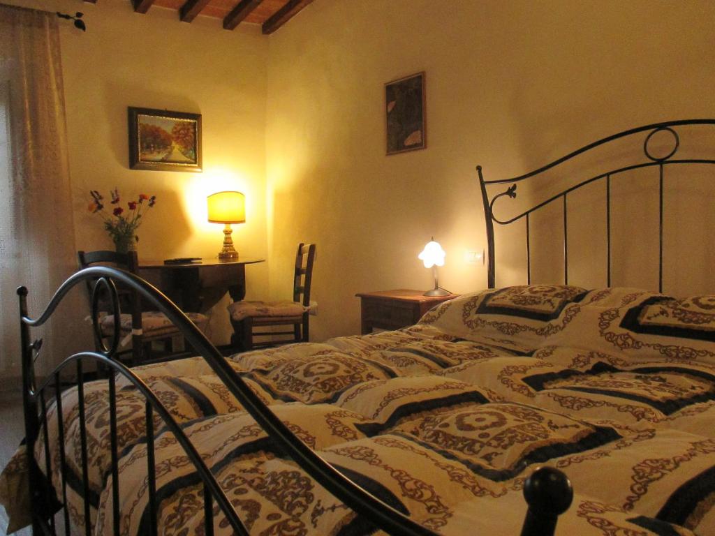 a bedroom with a bed and a table and a lamp at Podere Pian dei Gelsi in Volterra