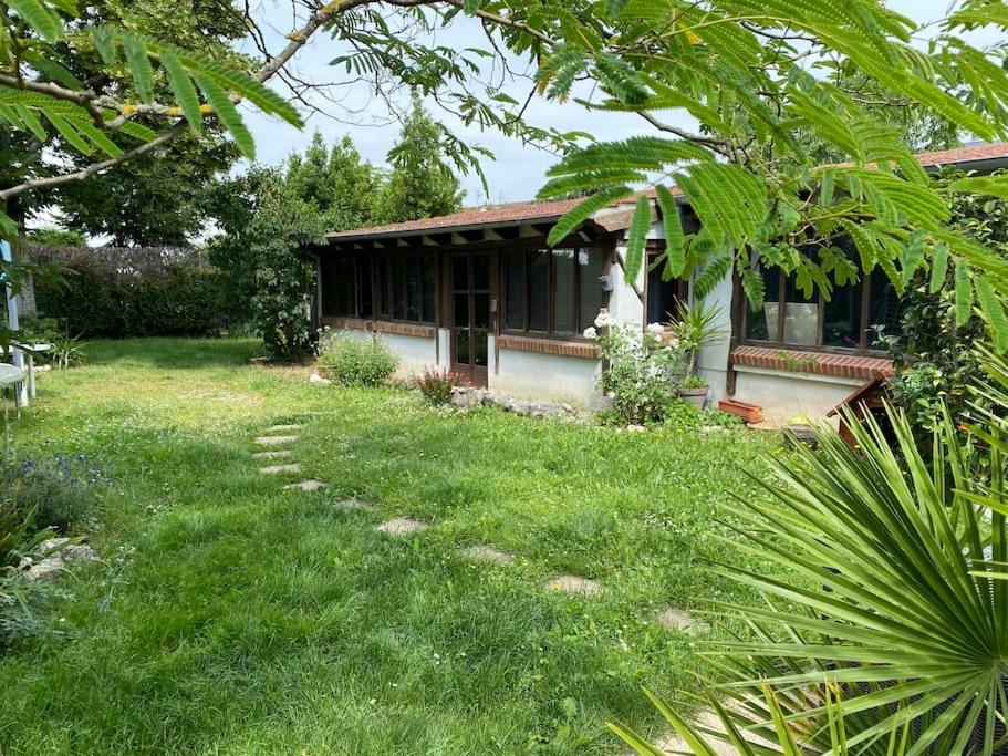 une maison dans une cour avec une pelouse verte dans l'établissement La cabane au fond du jardin, à Orléans