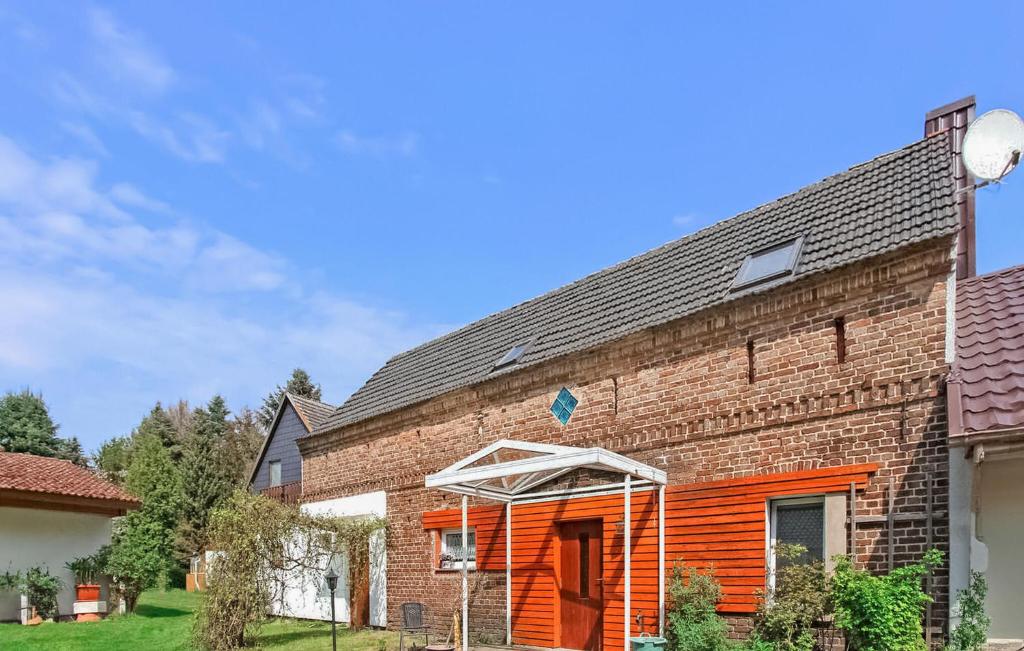 a brick building with an orange door and an umbrella at Stunning Apartment In Königs Wusterhausen Ot in Kablow