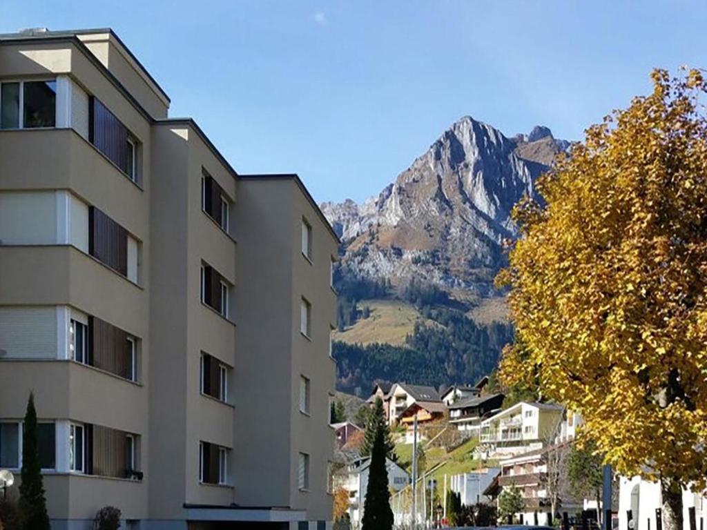 a building in a city with a mountain in the background at Apartment Alpenstrasse 621 by Interhome in Engelberg