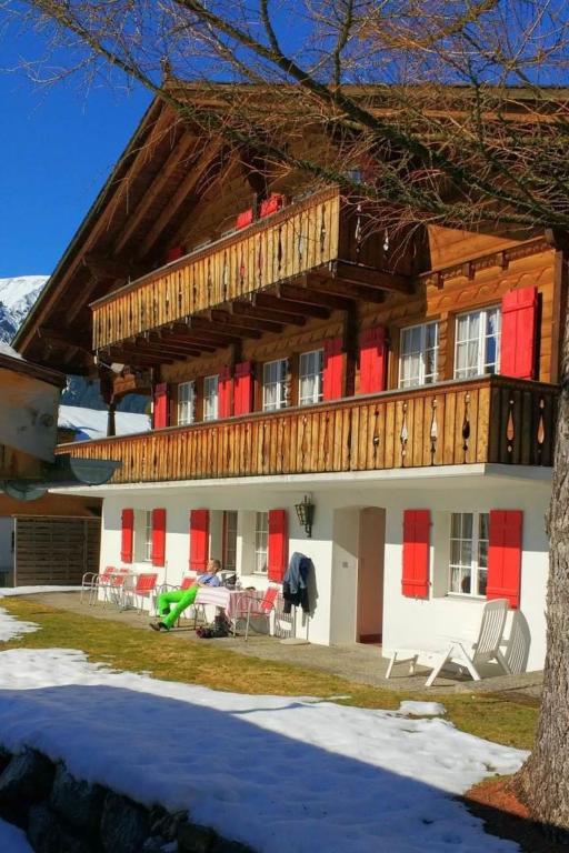 a large house with a deck on top of it at Apartment Bärnermutz # 2 by Interhome in Lenk