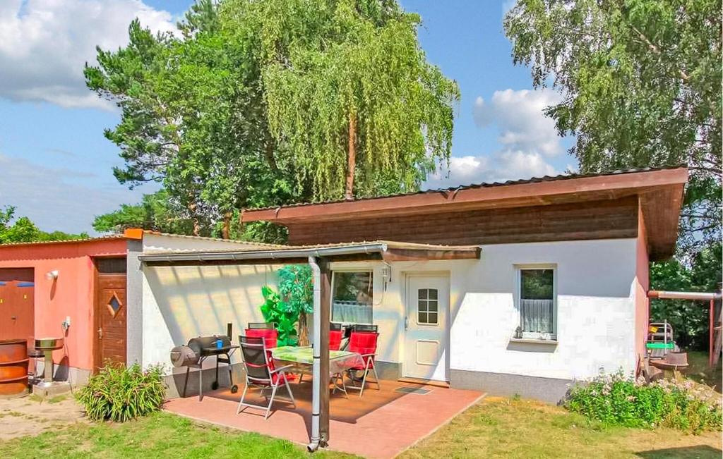 a small house with a patio with a table and chairs at Doppelhaushälfte Waren Müritz in Kölpinsee